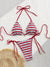 Striped bikini set with red, white, and blue colors on a textured surface.
